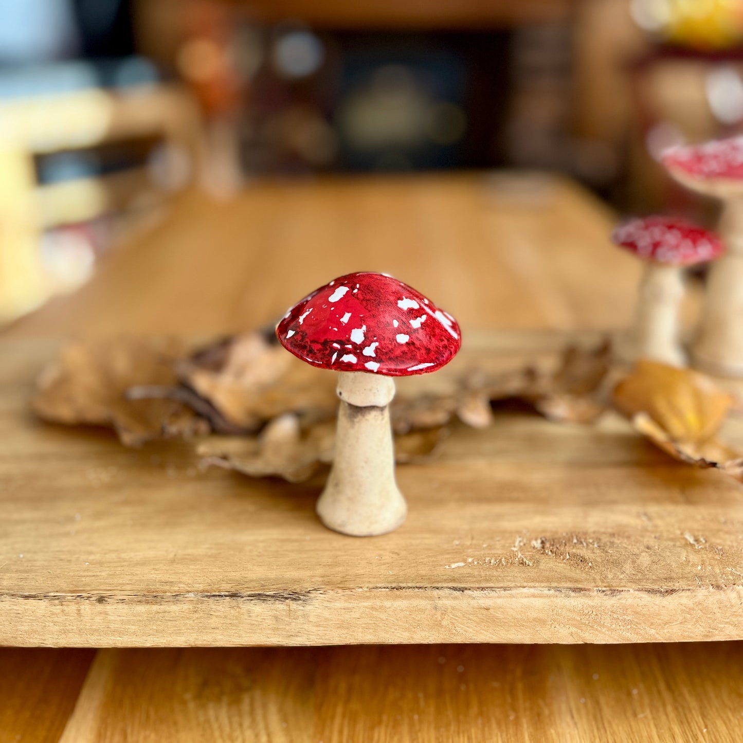 Decorative red and white mushroom on a wooden surface with a blurred background