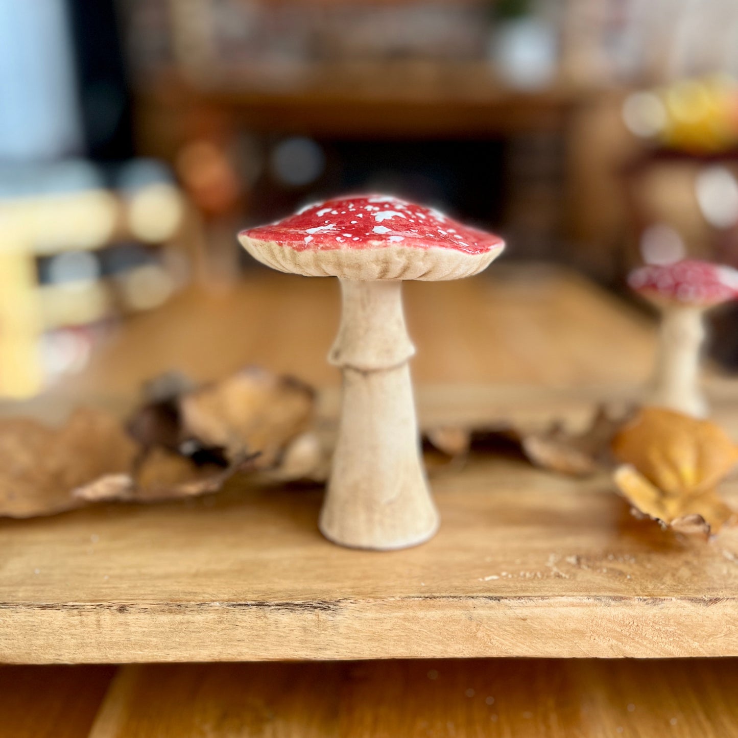 Large toadstool ornament on wooden shelf with blurred background