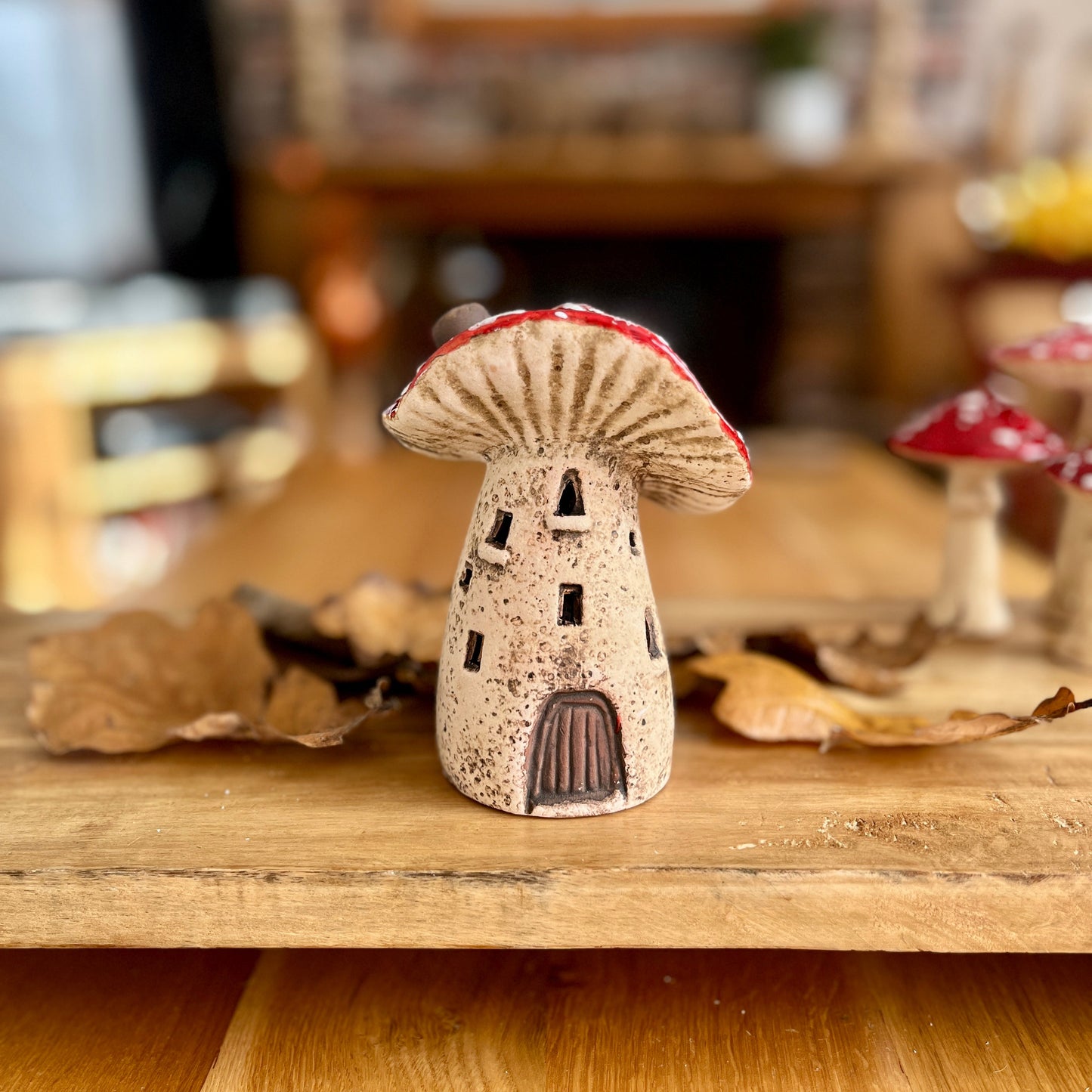 Ceramic mushroom sculpture on a wooden surface with a blurred background
