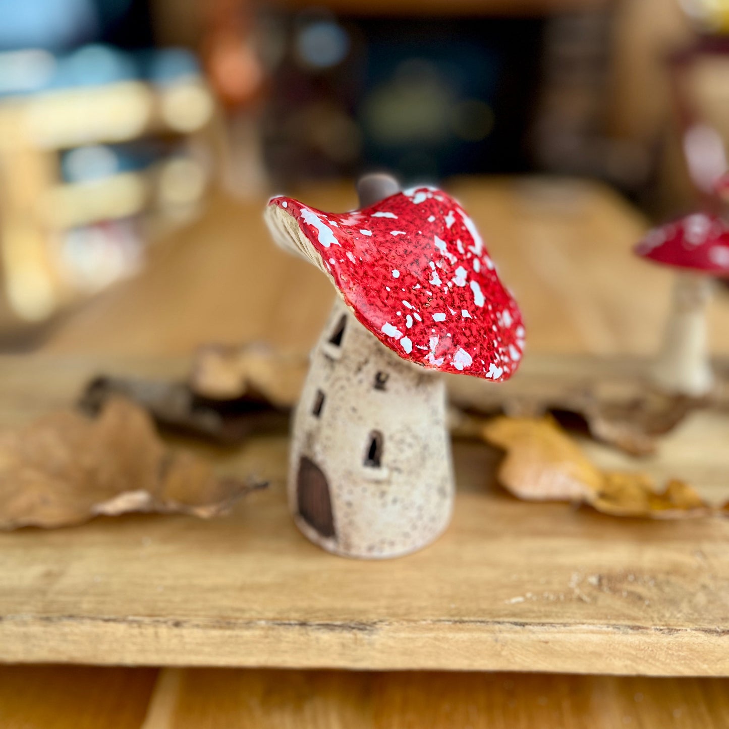 Small mushroom shaped ornament with a red cap on a wooden surface