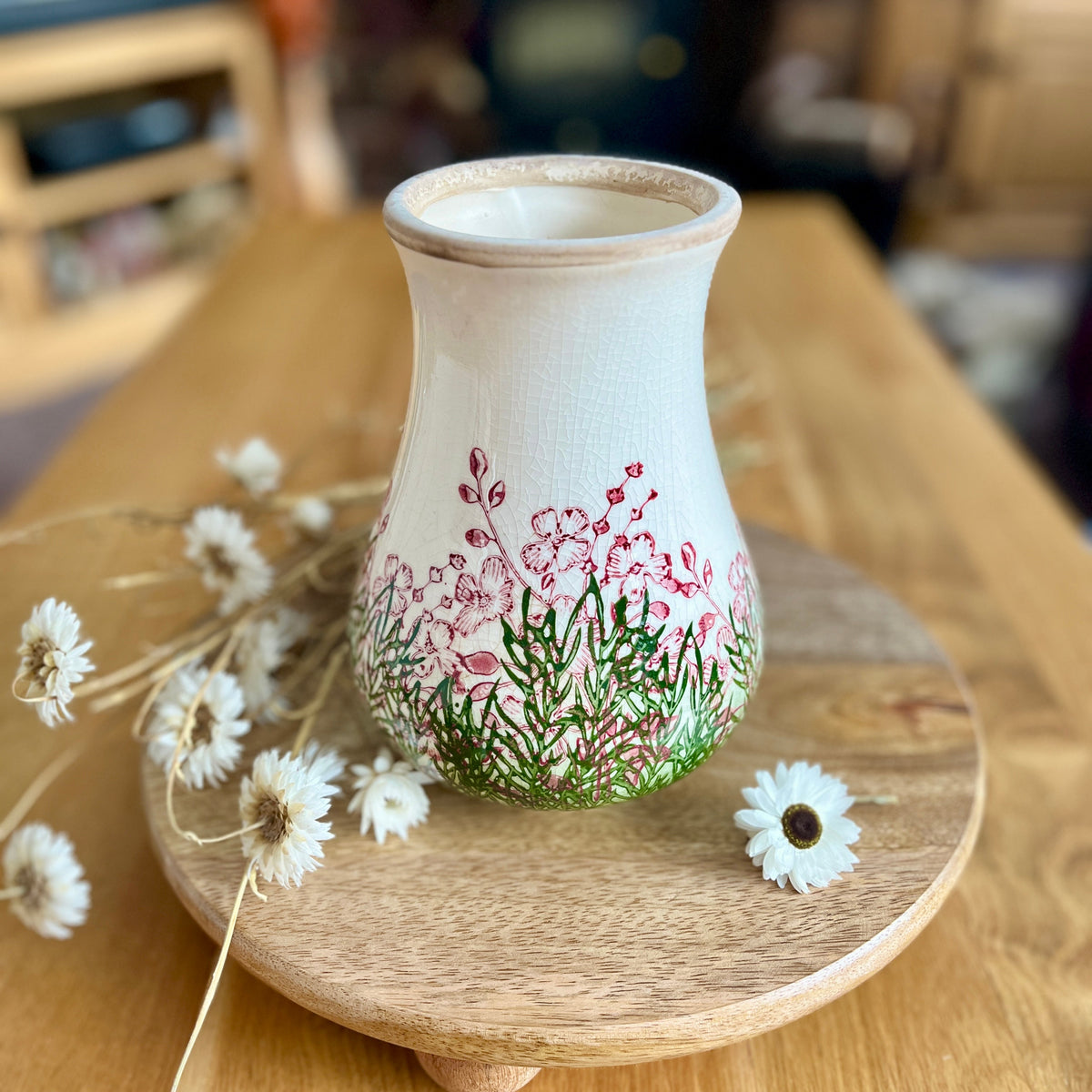 Decorative vase with floral design on a wooden surface