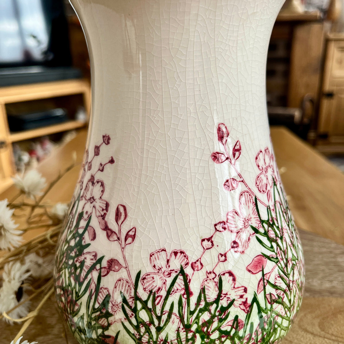 Decorative vase with floral design highlighting the crackle effect on a wooden surface