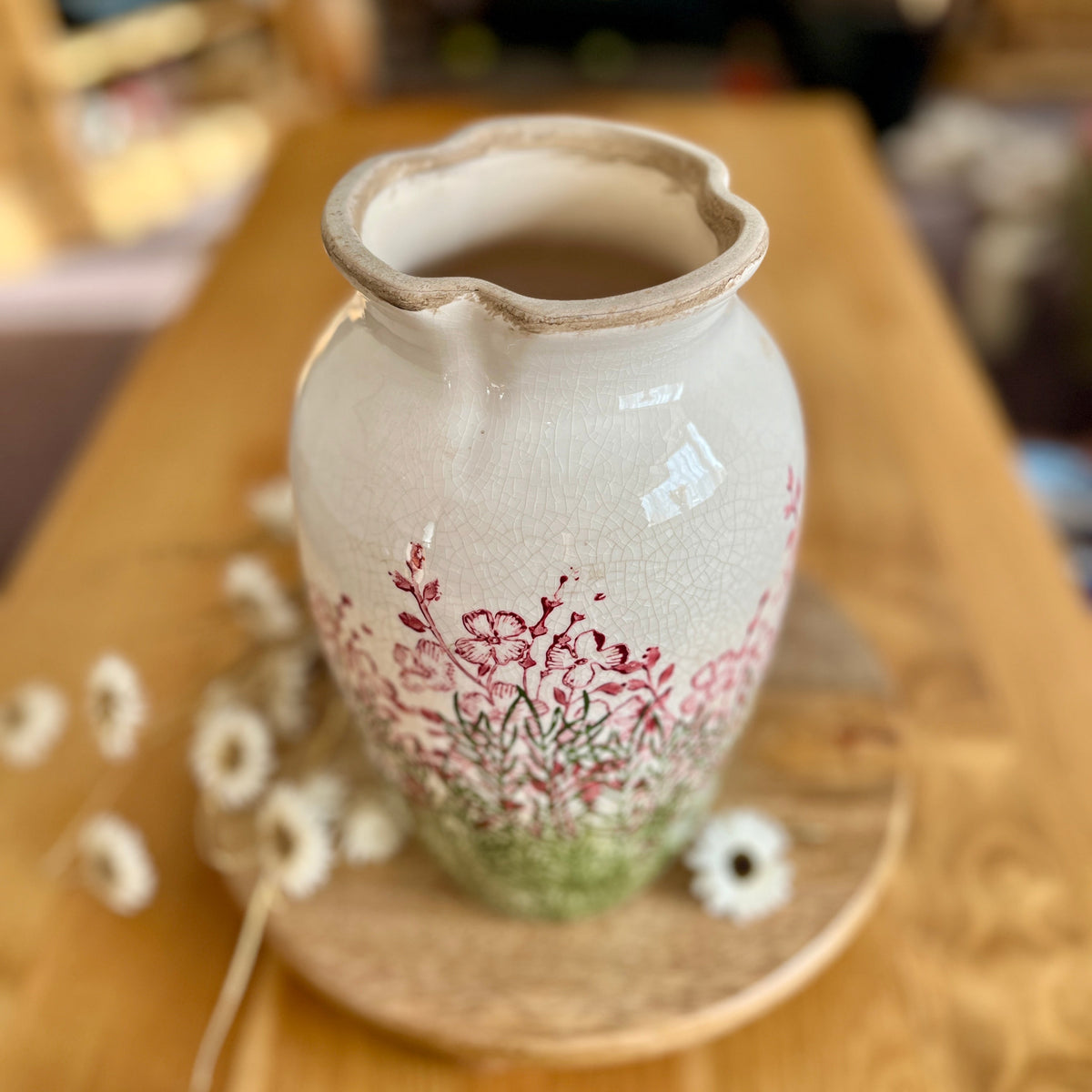 Ceramic vase with floral design on a wooden surface