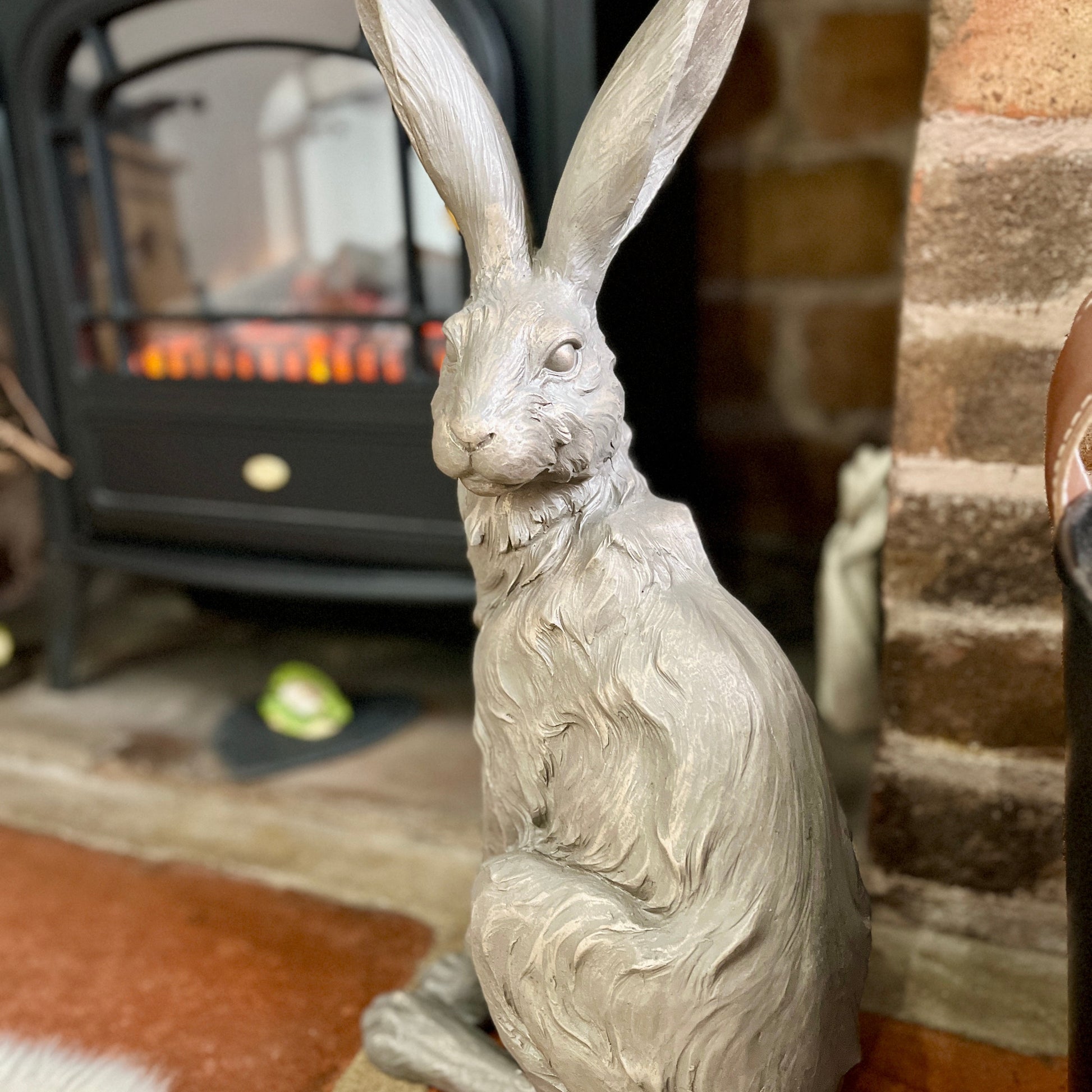 Close up of a decorative hare statue in front of a fireplace