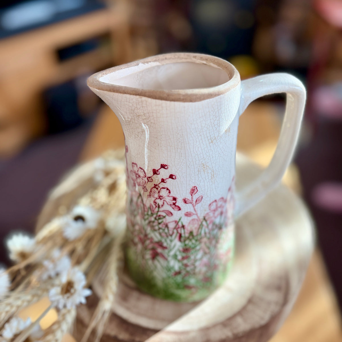 Ceramic jug - from above - with floral design on a wooden surface
