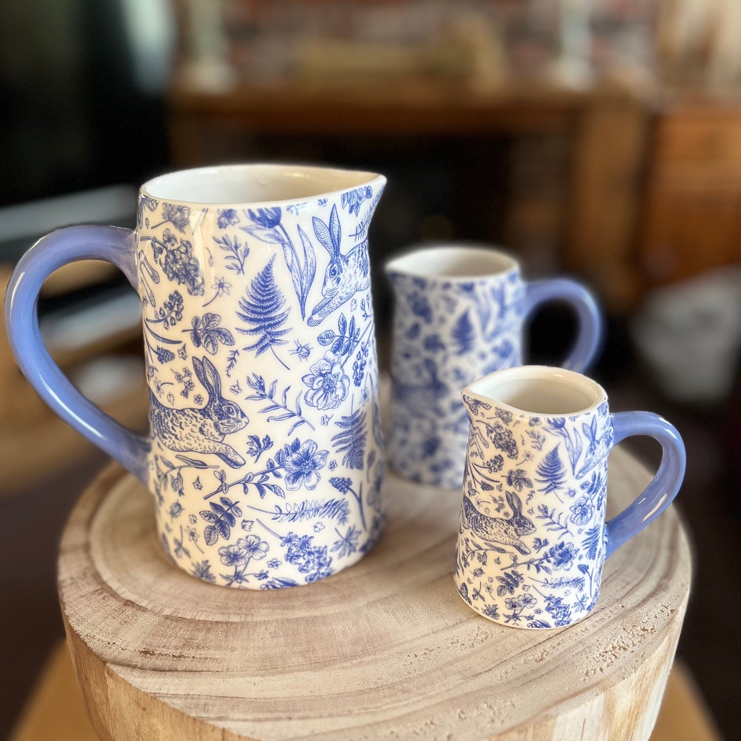Set of 3 Blue Rabbit Floral Jugs On Display On Stool