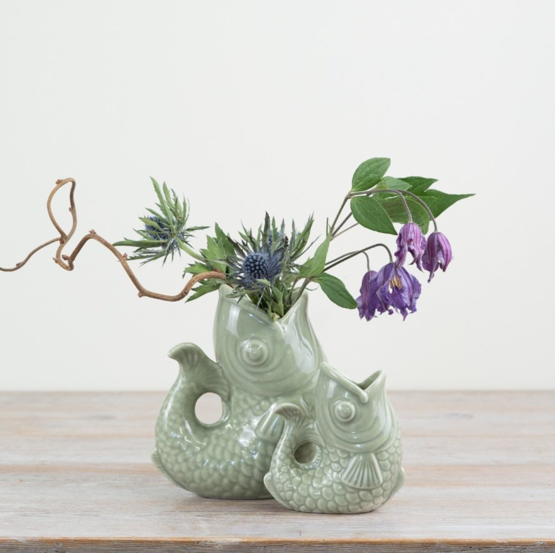 Gluggle jug in sage green as a stylish fish vase with flowers and twigs, showcasing unique ceramic design.