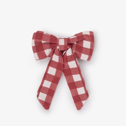 A small fabric bow in a red and white gingham check pattern, photographed against a plain light gray background.