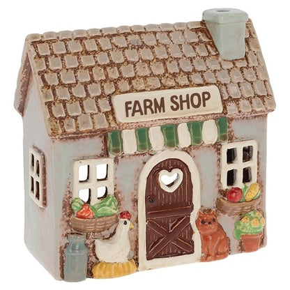 Decorative candle holder of a farm shop with animals and produce on a white background