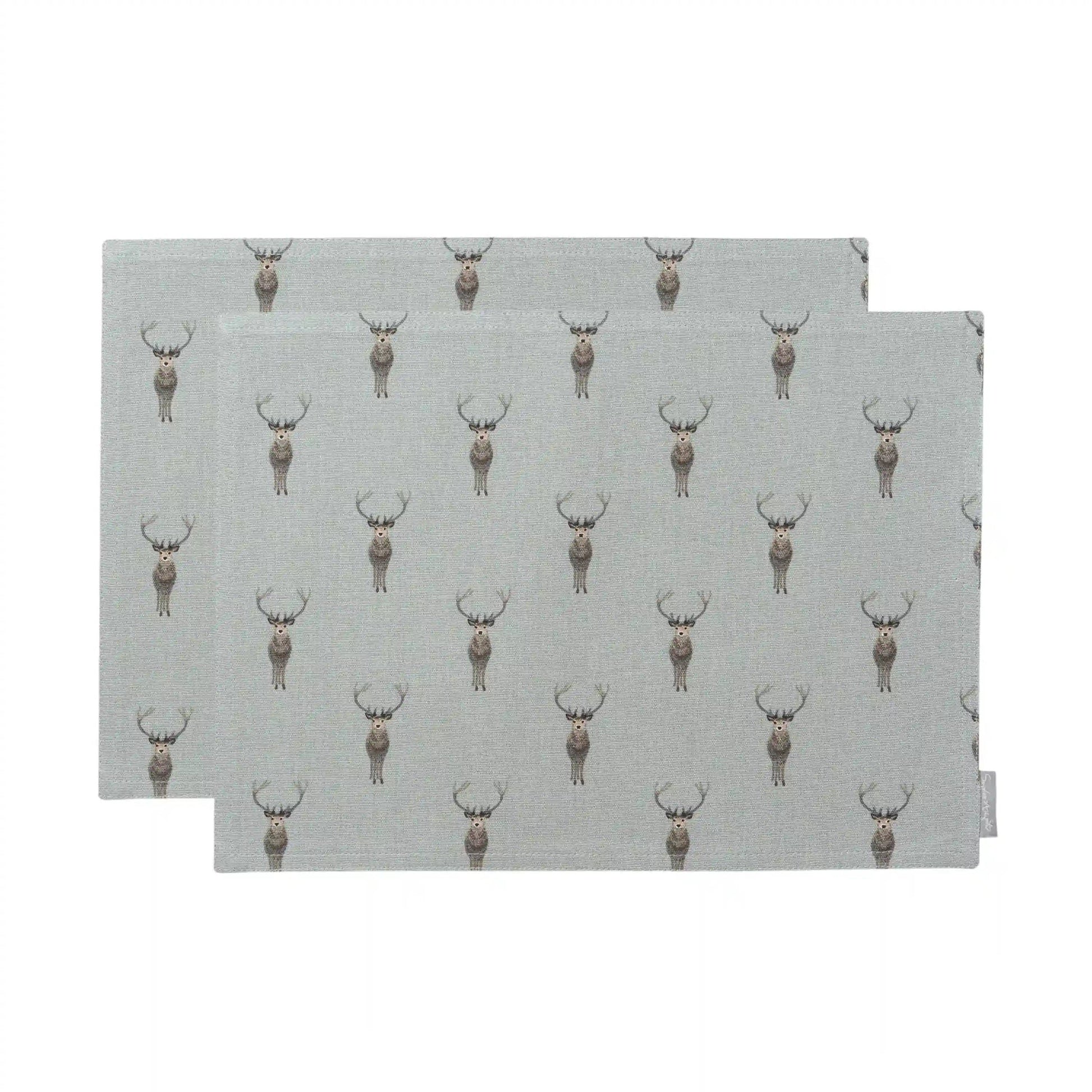 Two rectangular placemats with a repeating deer print on a light gray background, shown overlapping on a white studio background.