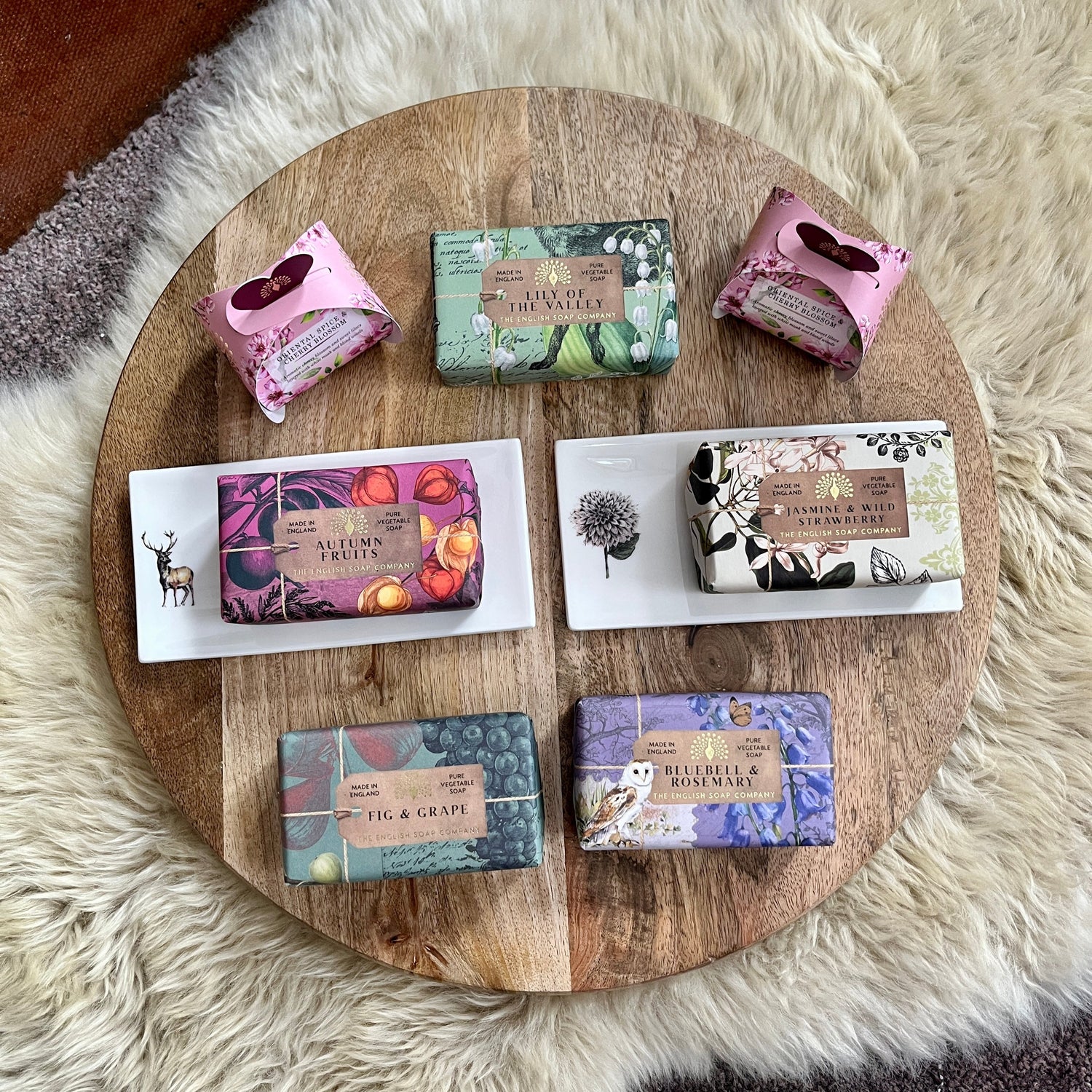 Assorted soaps on a wooden tray with a white fur background