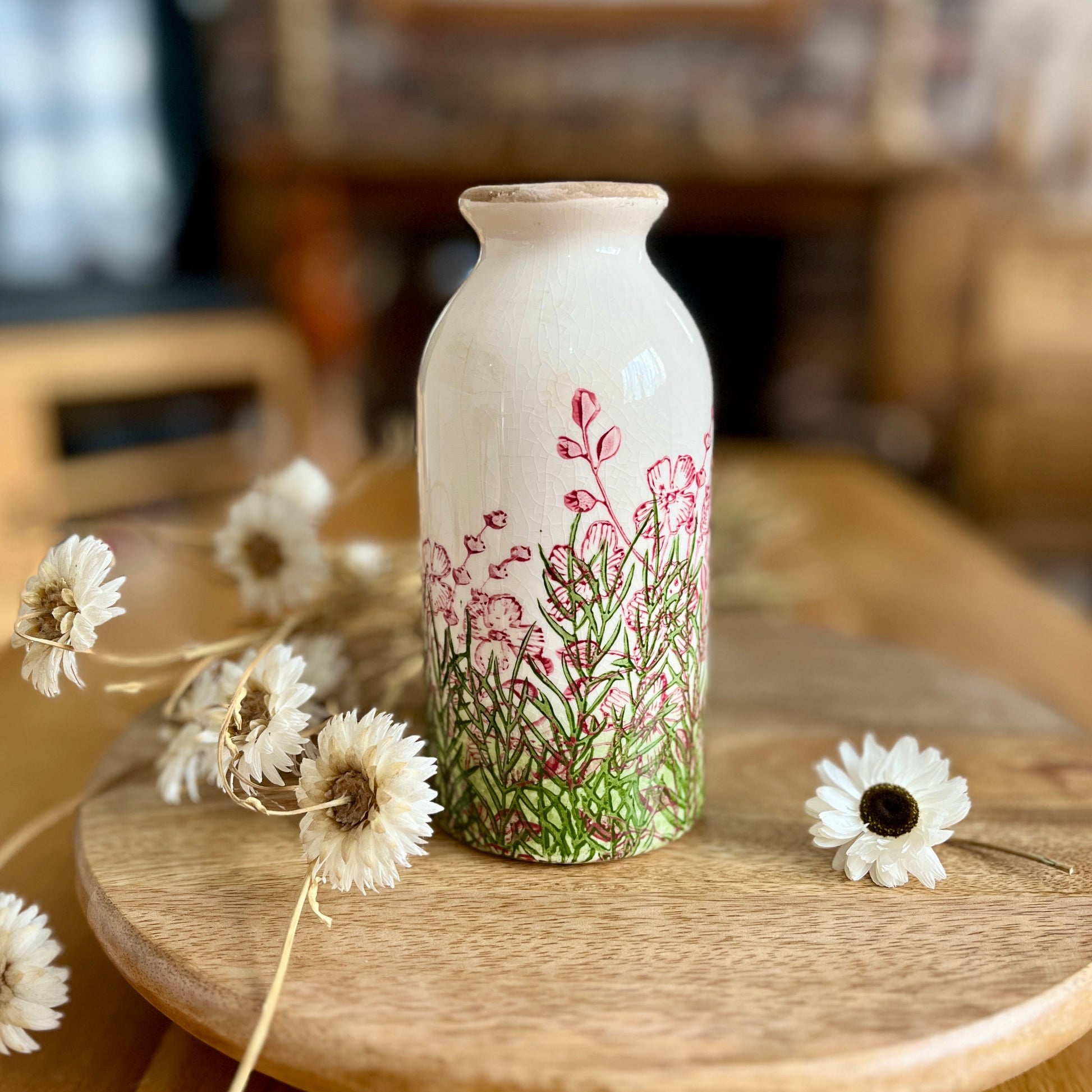 Decorative bottle shapedvase with floral design on a wooden table