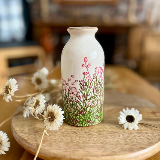 Decorative bottle shapedvase with floral design on a wooden table