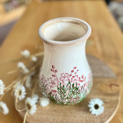 Decorative ceramic vase with floral design on a wooden surface