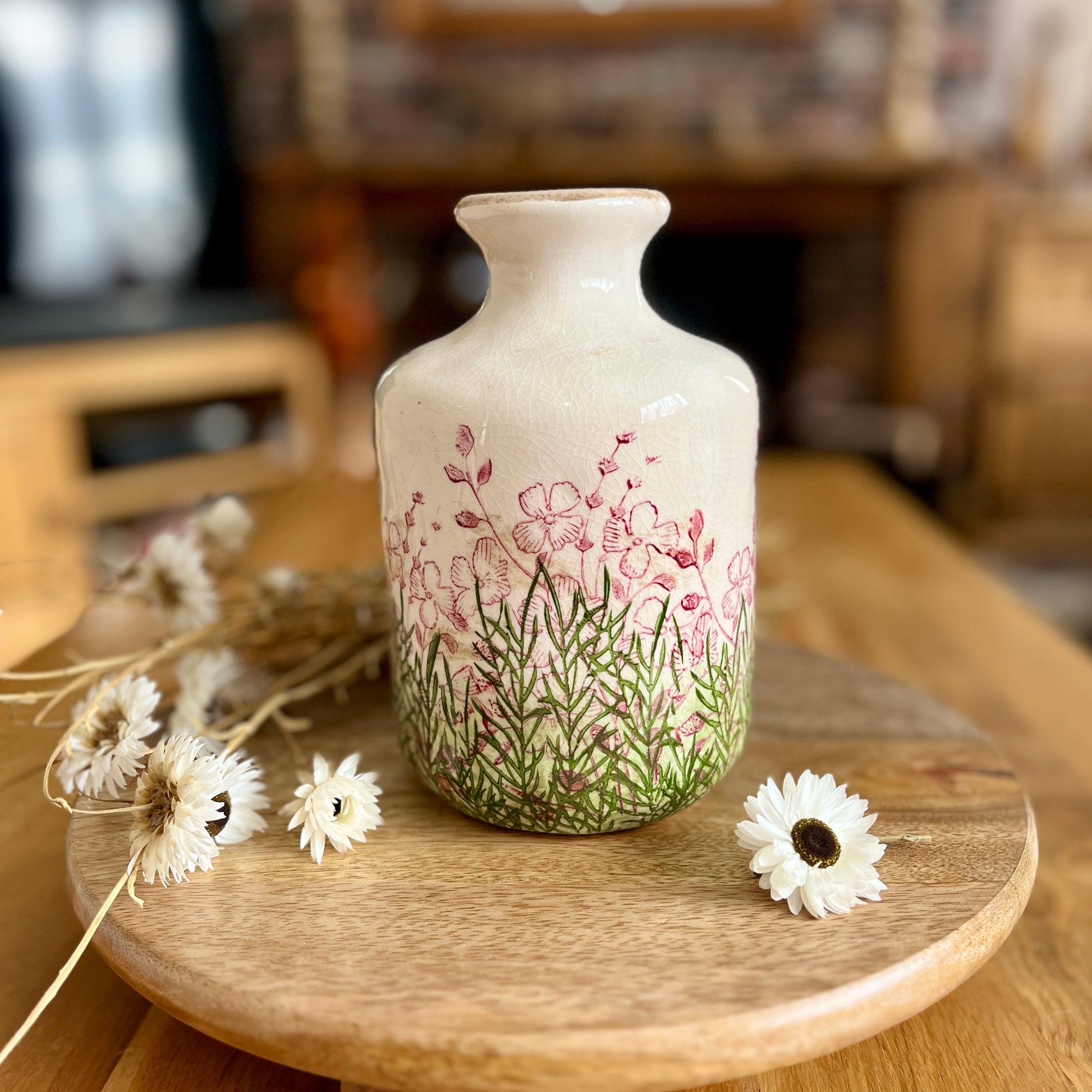 Decorative bottle vase with floral design on a wooden surface