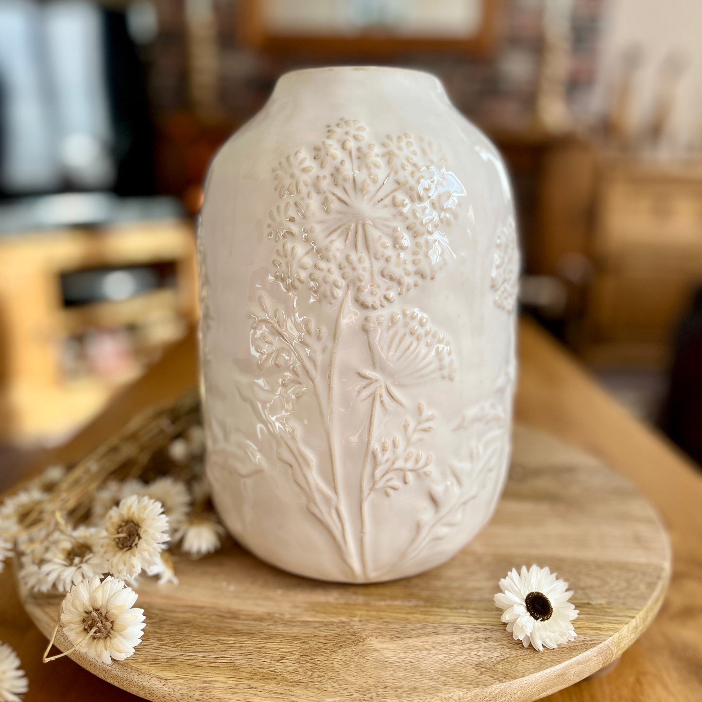 Decorative white vase with floral patterns on a wooden surface
