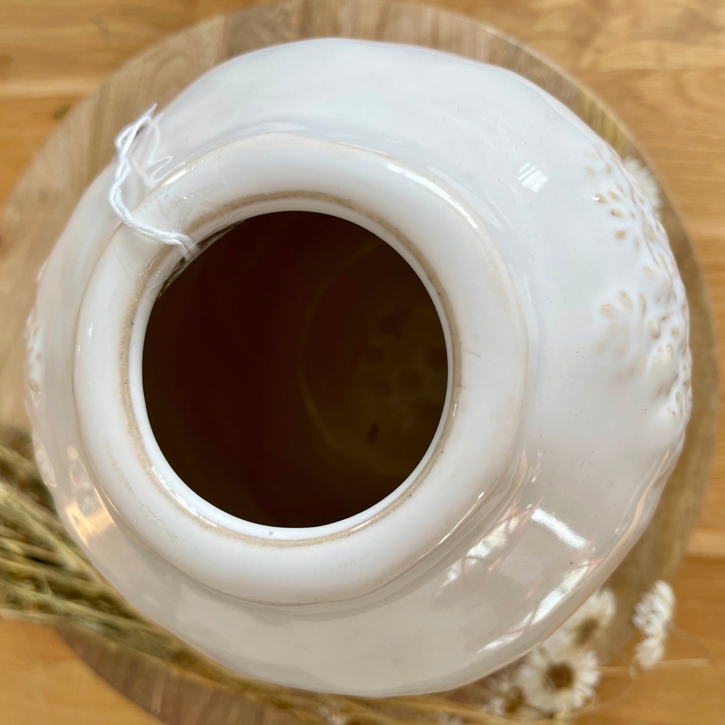Top of white ceramic vase looking inside on a wooden surface