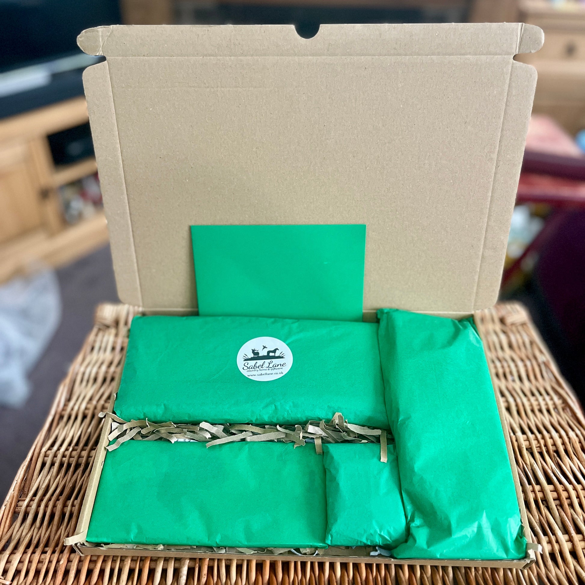 Green gift wrapped contents with a logo on a woven surface