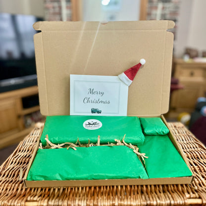 Gift box with green paper and a small gift note on top, placed on top of a wicker basket.