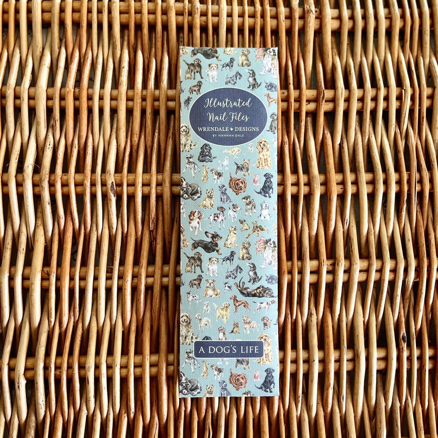 Pack of illustrated nail files with dog illustrations on a wicker surface
