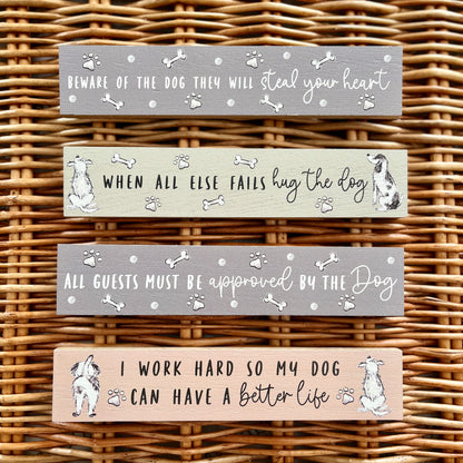 Four wooden signs with dog-themed sayings on a wicker background