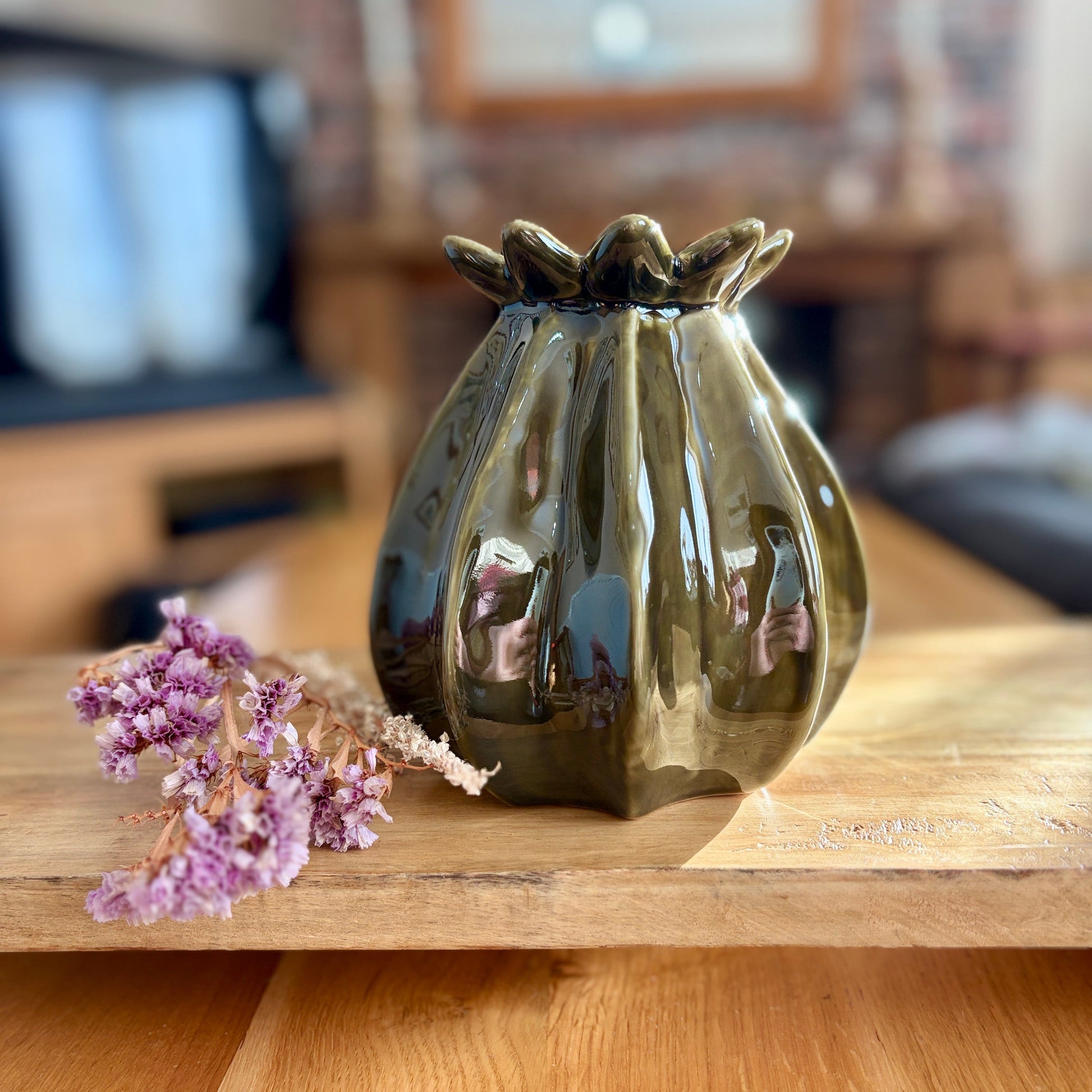 Decorative ceramic vase on a wooden surface with blurred background