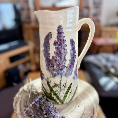 Ceramic jug with lavender design on a wooden stand in a home setting