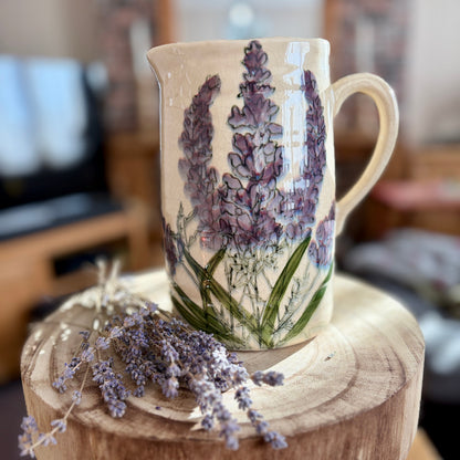 Ceramic jug with floral design on a wooden stool