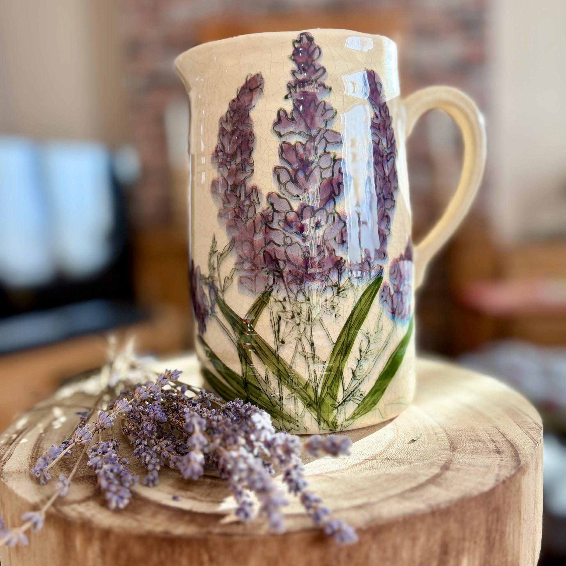 Ceramic jug with floral design on a wooden surface