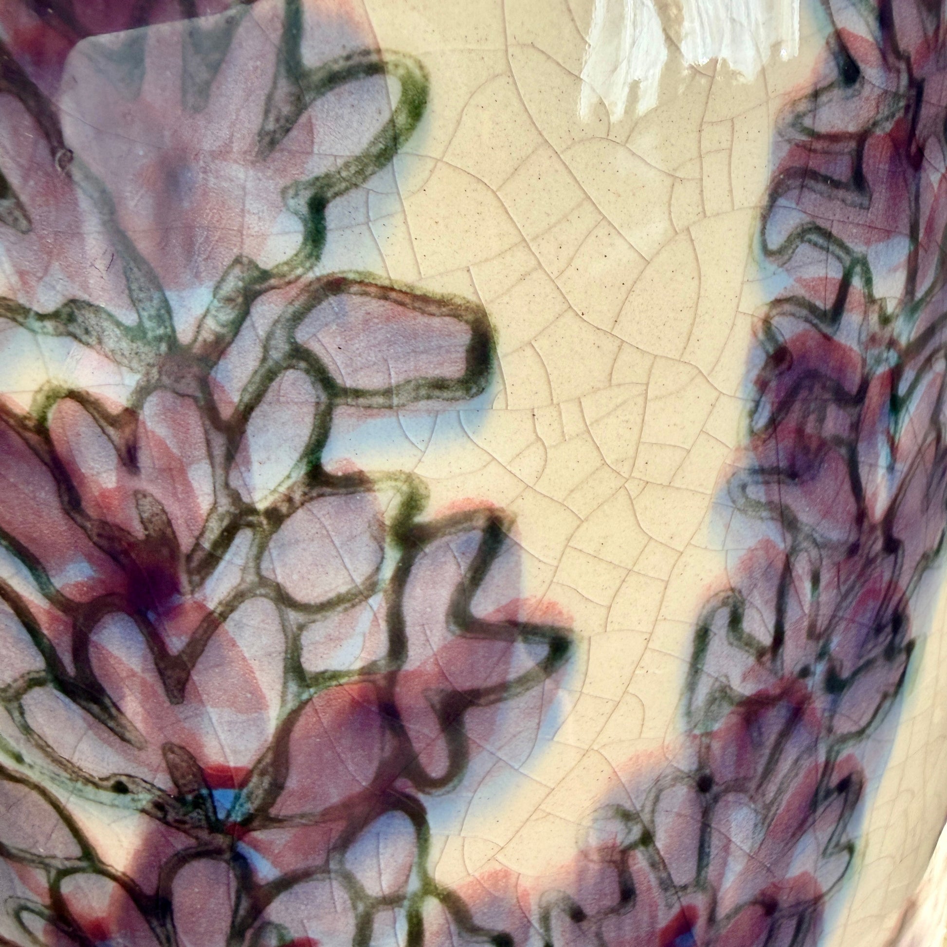 Close-up of a ceramic jug with floral patterns and a cracked texture.