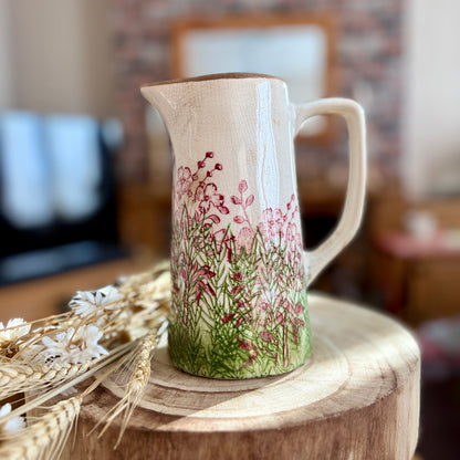 Decorative ceramic jug with floral design on a wooden surface