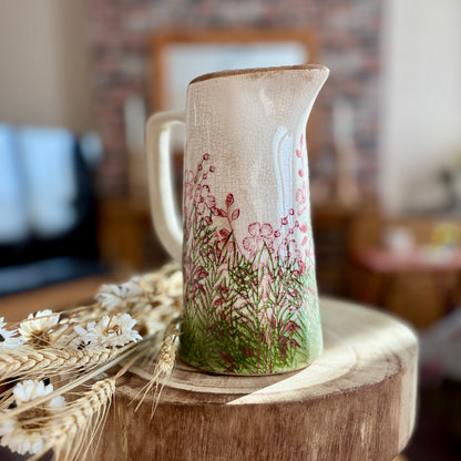 Decorative jug- front view -  with floral design on a wooden stool in a blurred indoor setting