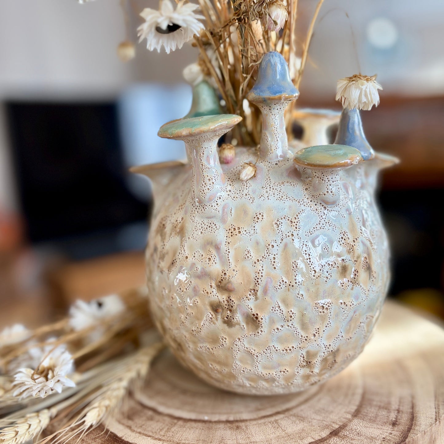 Decorative ceramic vase with mushroom design on a wooden surface