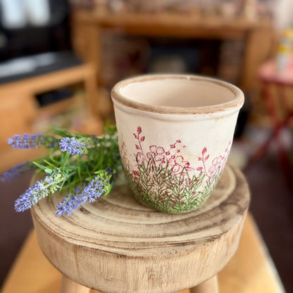 Floral ceramic plant pot from above, sat on a stool with lavender with blurred background