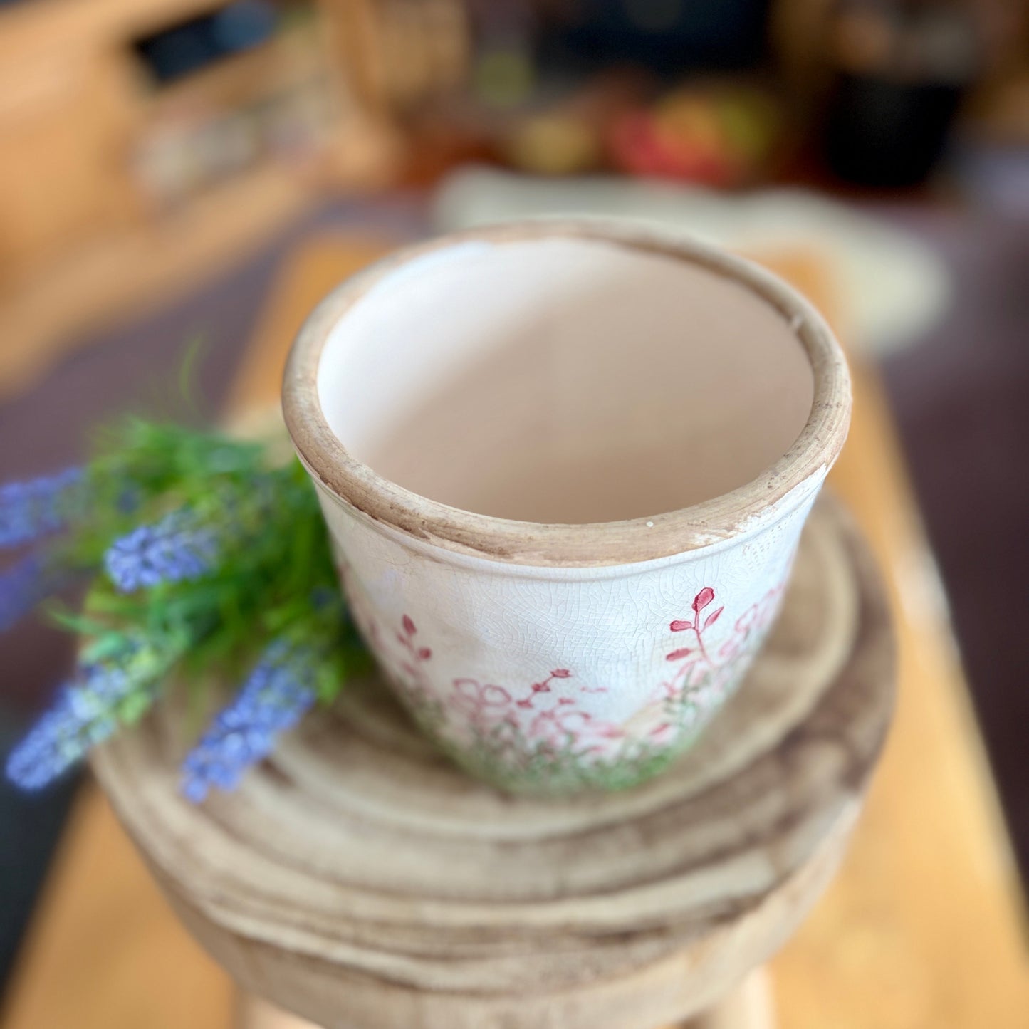 Floral planter from above showing the stoneware design with a blurred background.