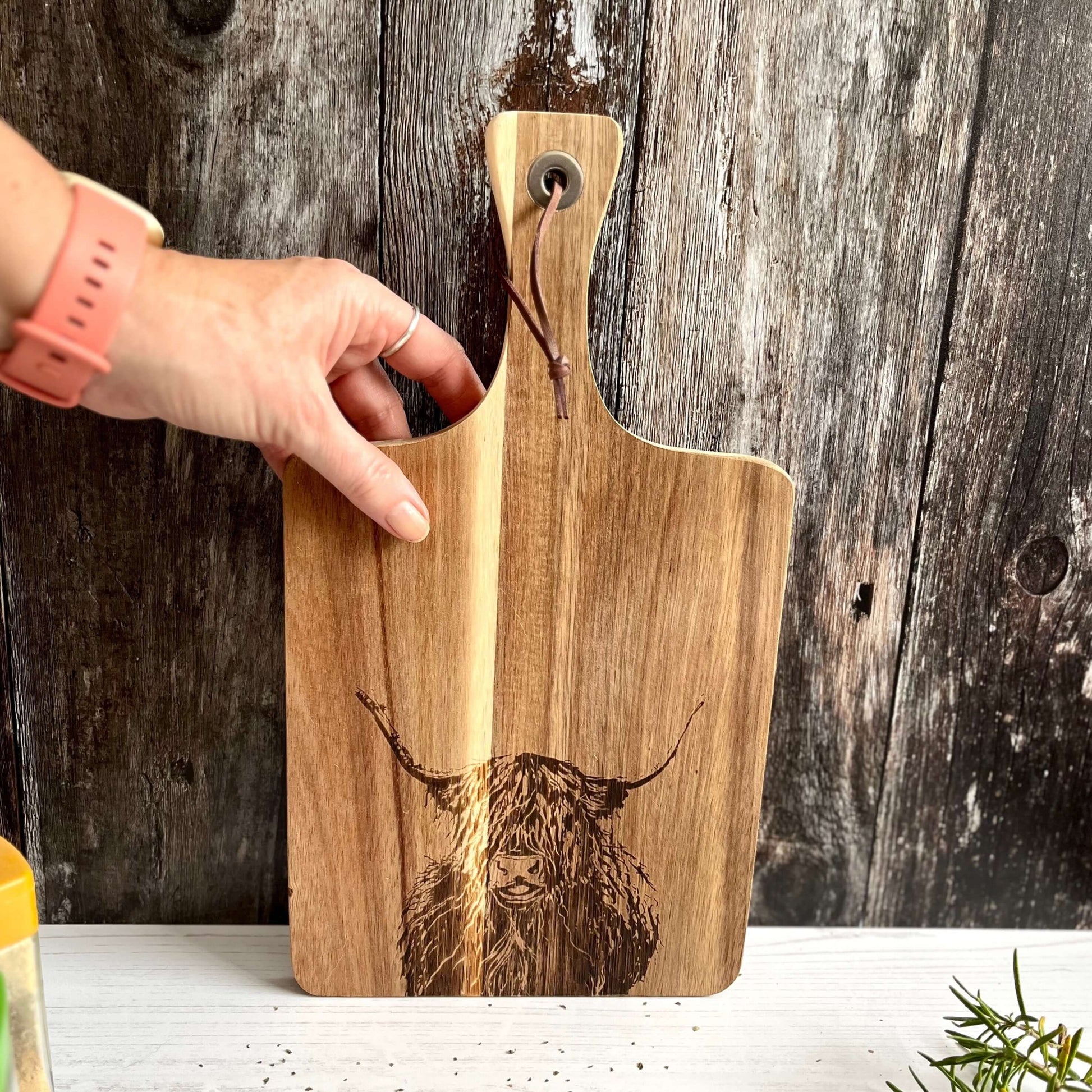 Highland Cow Cutting Board With Hand Picking it Up