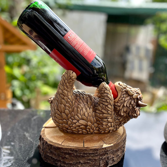 Highland Cow Bottle Holder Being Demonstrated for its Purpose with a Bottle of Wine